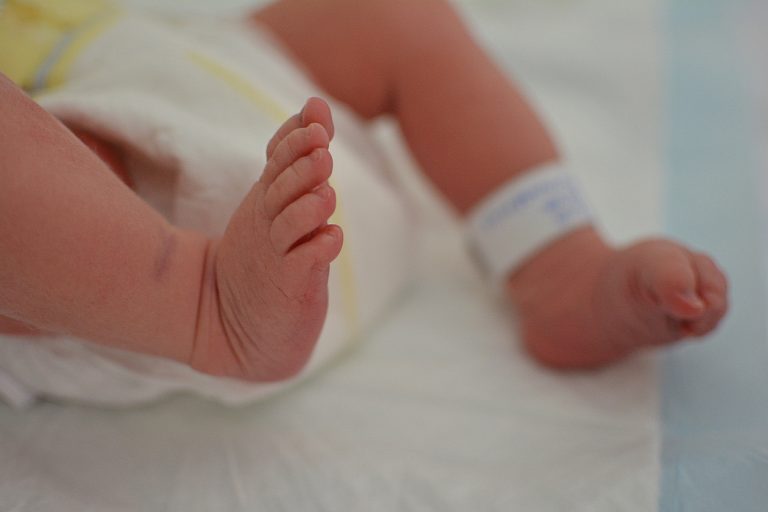 CLOSE-UP NEWBORN BABY AT THE HOSPITAL WITH IDENTIFY TAG ON FEET AND DIAPER.