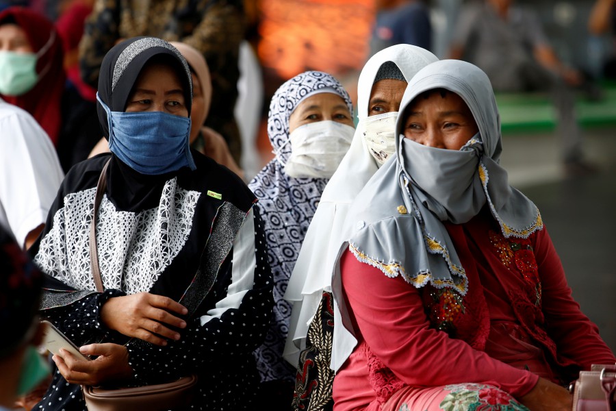 People wear protective masks after Indonesia confirmed its first cases of coronavirus disease (COVID-19), in Soekarno Hatta International Airport, in Tangerang near Jakarta
