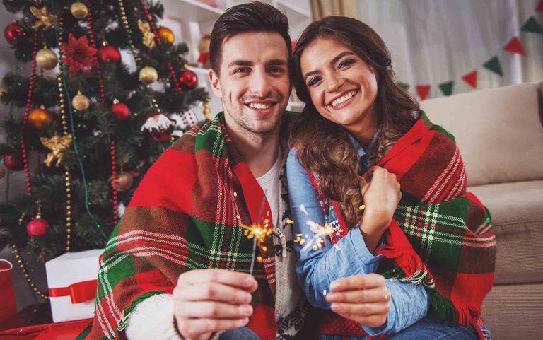 Young happy couple during the celebration of Christmas at home